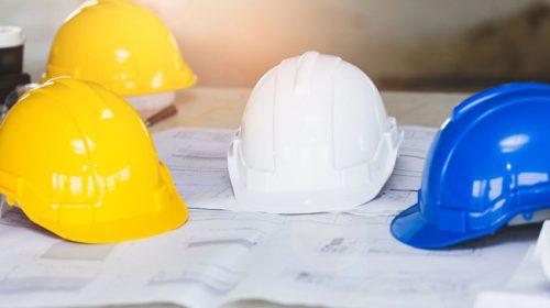 Hardhats on top of a set of blueprints